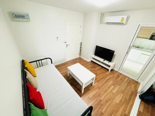 a living room with a white couch and a television at Maesod Mountain View in Mae Sot