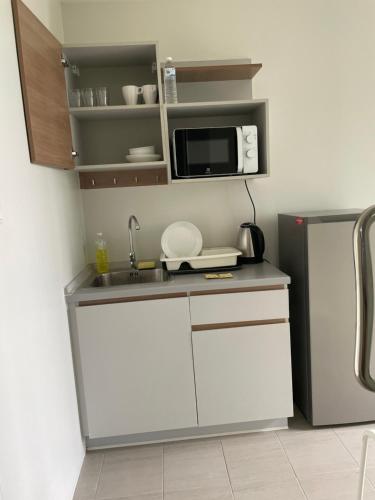 a small kitchen with a sink and a microwave at Maesod Mountain View in Mae Sot