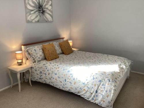 a bedroom with a bed and a table with two lamps at Cottage in North Somerset in Clevedon
