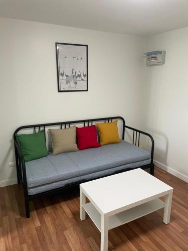 a couch with colorful pillows and a table in a room at Maesod Mountain View in Mae Sot