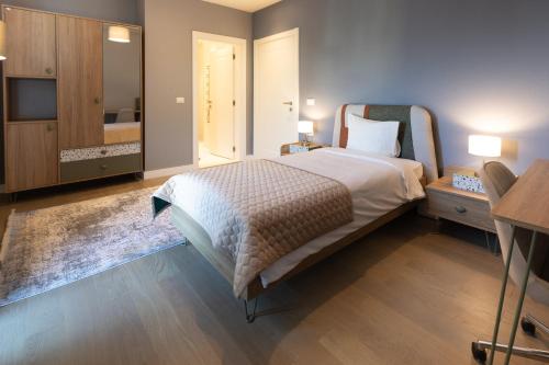 a bedroom with a large bed with a dresser and a table at Dreamland Golf Hotel Baku in Baku