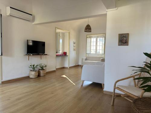a living room with a couch and a tv at T'Inácia Guest House in Évora