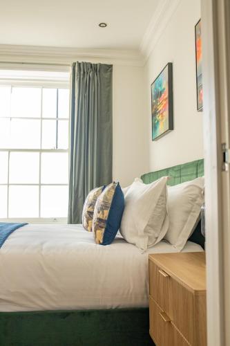 a bedroom with a white bed with pillows and a window at Charles Hope Salisbury Centre in Salisbury