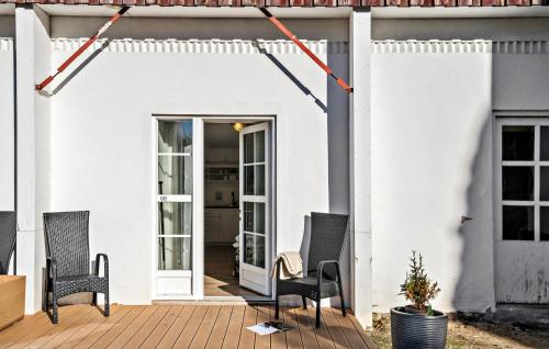 a white house with chairs on a patio at Lejl 66 in Skanderborg
