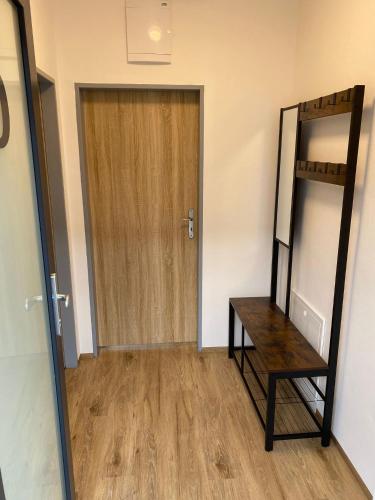 a hallway with a mirror and a wooden door at JK Apartmány in Bělkovice