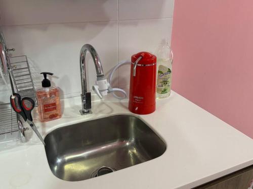 un lavello con contenitore rosso accanto di Hello Kitty HomeStay - Cameron Highlands - Spacious Studio - Perfect for Families - Sleeps 4 and Baby a Tanah Rata
