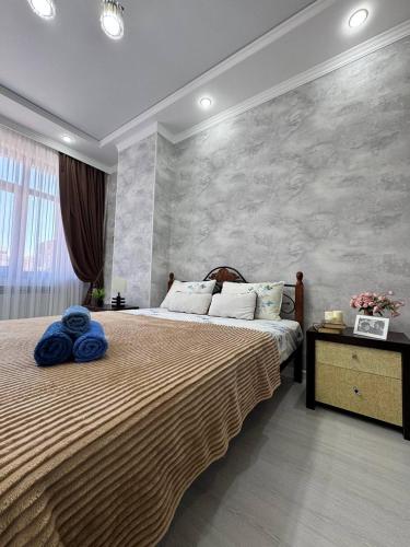 a bedroom with a large bed with blue towels on it at Гармония стиля in Aktau