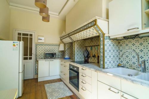 Il comprend une grande cuisine équipée d'un évier et d'un réfrigérateur. dans l'établissement Studio Jardin à la Villa Odette, à Toulouse