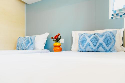 a bedroom with two beds with blue and white pillows at Atlantica Parc in Taghazout