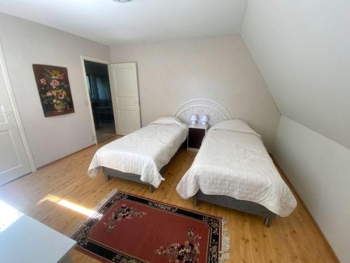a bedroom with two beds and a rug at Villa Nisula - yläkerran asunto in Teuva