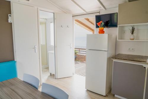 a kitchen with white appliances and a refrigerator at Atlantica Parc in Taghazout