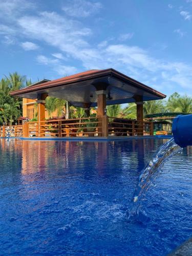 a fountain in a pool with a gazebo at Anelasplace Freshwater Resort in Calamundingan