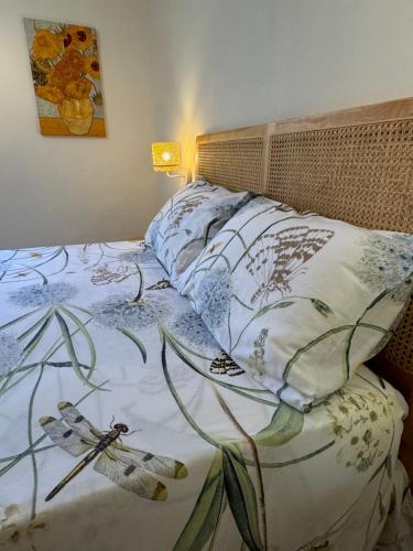 - un lit avec une couette et des oreillers à fleurs dans l'établissement Côté plage Mourillon, à Toulon