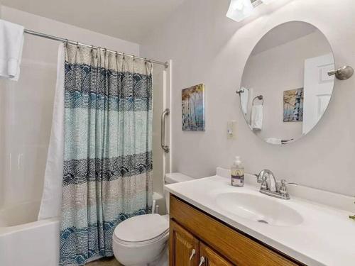 a bathroom with a sink and a toilet and a mirror at Family fun on the lake! in Reeds Spring