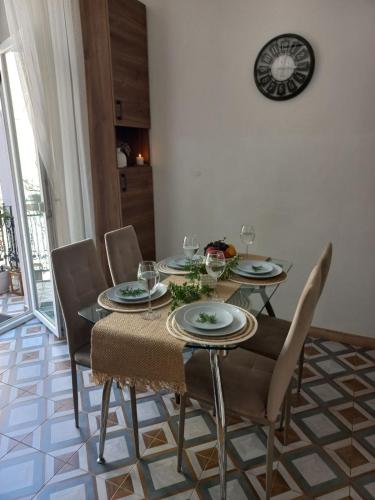 a dining room table with chairs and a clock on the wall at Fiesta Apartment on Franka 2BR-6P in Lviv