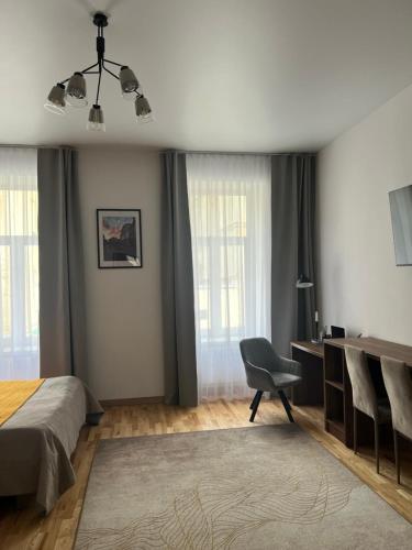 a bedroom with a bed and a desk and a chair at Fiesta Apartment on Franka 2BR-6P in Lviv