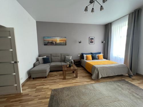 a bedroom with a bed and a couch at Fiesta Apartment on Franka 2BR-6P in Lviv