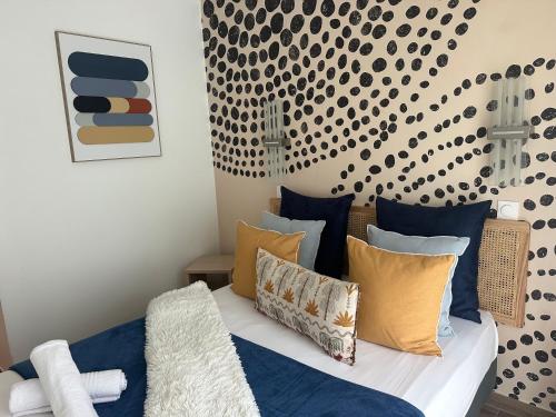 a bedroom with a bed with blue and yellow pillows at Immodēly & la Magie de Disney in Serris