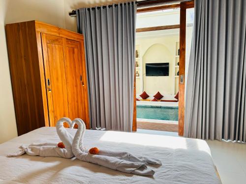 una decoración de cisne en una cama en un dormitorio en Kelapa Villa Mambal, en Mambat