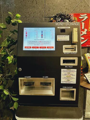 a money exchange machine with a screen on it at HOTEL SUI AKASAKA by ABEST in Tokyo
