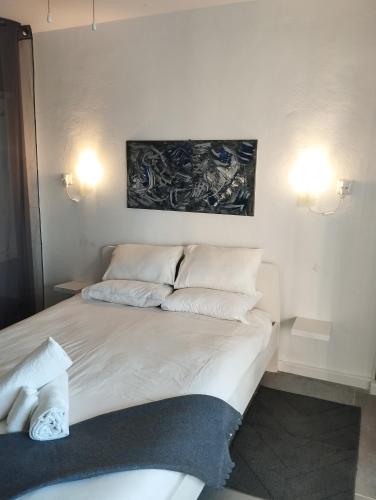 a bed with white pillows and a painting on the wall at Sea View Calypso Condo in Mijas