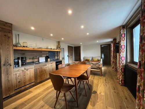 une cuisine et une salle à manger avec une table et des chaises en bois dans l'établissement La Belle Etoile, à Saint-Gervais-les-Bains