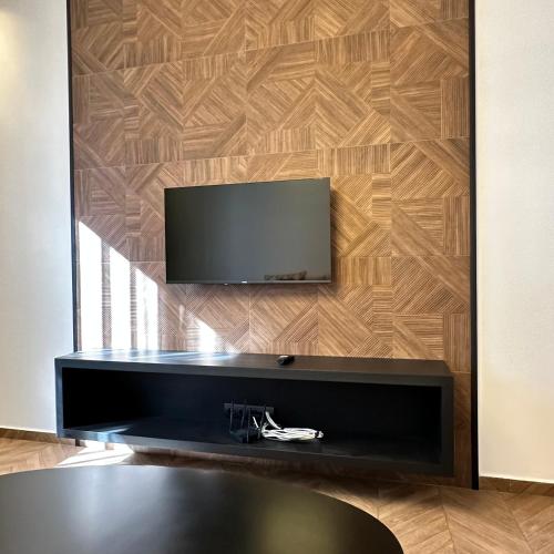 a flat screen tv hanging on a wooden wall at Supérieur Suite Balima B25 in Rabat