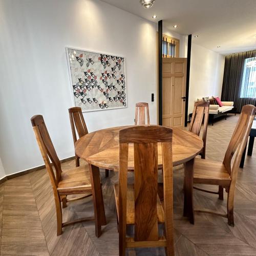 a dining room with a wooden table and chairs at Supérieur Suite Balima B25 in Rabat