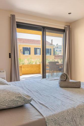 une chambre avec un lit et une porte coulissante en verre dans l'établissement Résidence Le Provence, au Lavandou