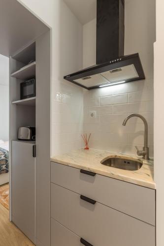 a kitchen with a sink and a stove at Casa Camarinhas in São Jacinto