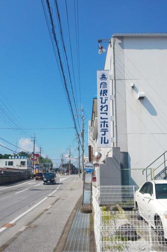 a sign on the side of a building next to a street at 彦根びわこホテル裏のマンション 一室貸し切り50台無料駐車場付き台所あり自転車貸出可 BbQ可 ペット同伴可 in Hikone