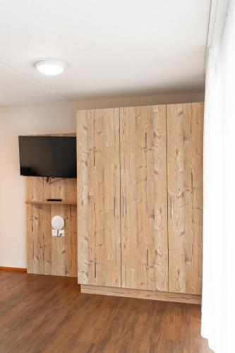 a room with wooden walls and a flat screen tv at Wohntel - wohnen wie im Hotel in Sevelen