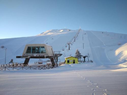a ski lift on a snow covered mountain with footprints in the snow at [vista Sibillini] Villa Amici in Verri
