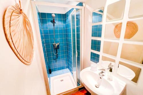 une salle de bain carrelée bleue avec un lavabo et une douche dans l'établissement 84B9 - 
