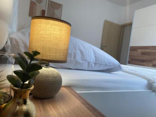 a lamp sitting on a table next to a bed at Holiday Home Mihaela in Višnjan