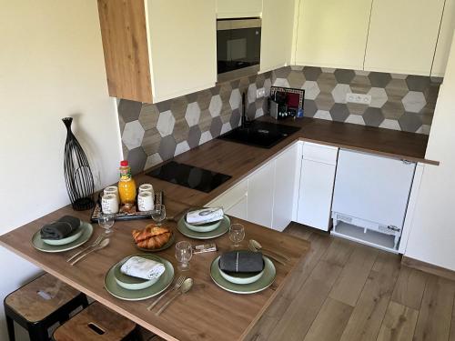 a kitchen with a table with plates of food on it at Immodēly & la Magie de Disney in Serris