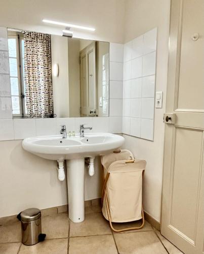une salle de bain avec un lavabo et un miroir dans l'établissement 'Petit Béguin' au coeur d'Uzès, à Uzès
