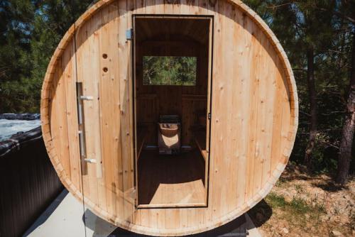 a wooden barrel house with a dog in the doorway at The Creekview,Luxury Safari Tent in Cadiz