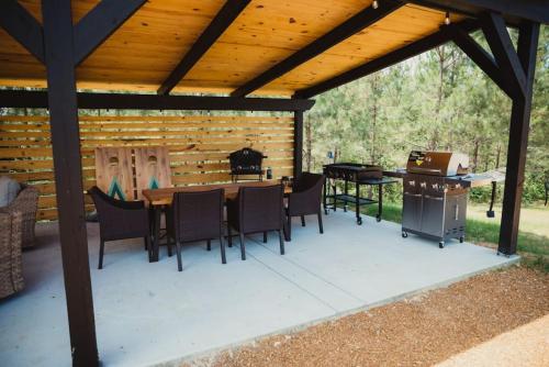 a patio with a table and chairs and a grill at The Creekview,Luxury Safari Tent in Cadiz