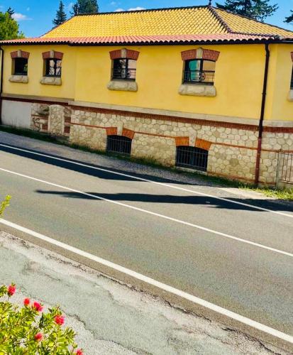 a yellow building with windows on the side of a road at Logis hôtel et restaurant La Bastide Cabezac in Bize-Minervois