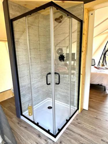 a glass shower enclosure in a room with a bed at Entire Glamping Campground, 8 Luxury Safari Tents in Cadiz