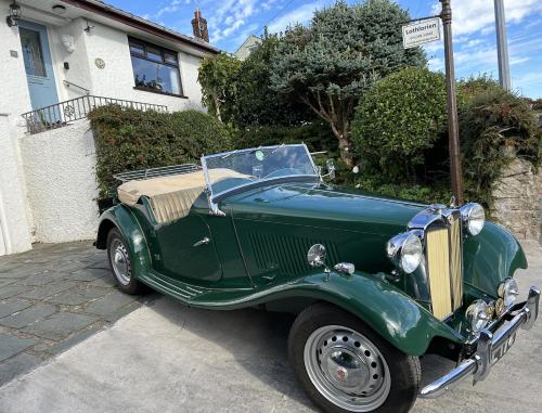 an old green car parked in front of a house at Kents Bank Holiday - Pet Friendly with Bay Views in Grange Over Sands