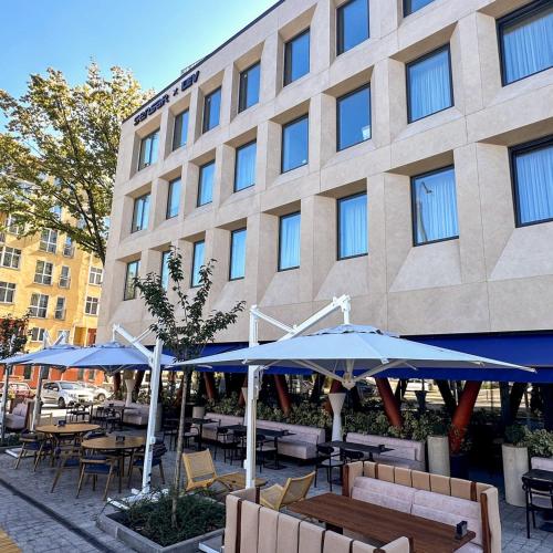 a building with tables and umbrellas in front of it at Smart House Apartments in Lviv