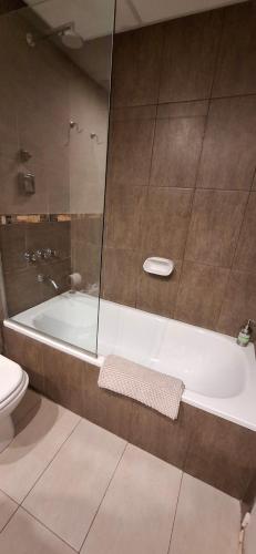 a bathroom with a bath tub and a toilet at El encanto del lago in San Carlos de Bariloche