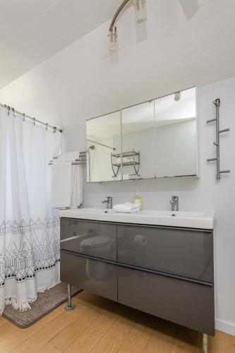 a bathroom with a sink and a mirror at Den Street Cottage in Los Alamos