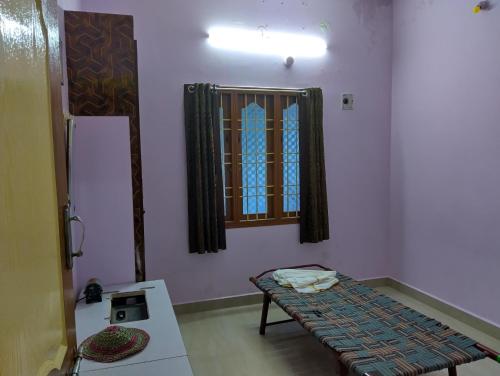 una habitación con un banco y una ventana en ella en Arunachala Home Stay, en Tiruvannāmalai