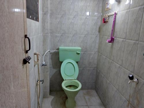 y baño con ducha y aseo verde. en Arunachala Home Stay, en Tiruvannāmalai