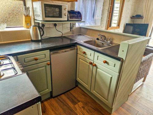 a kitchen with a sink and a microwave at Clyne Farm Centre in The Mumbles