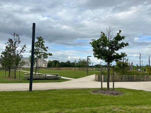 a park with a bench and a tree in the grass at Immodēly & la Magie de Disney in Serris