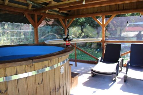 a large pool in a pavilion with two chairs and a table at Kiruly Gyöngye in Băile Chirui